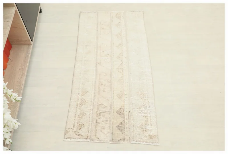 Full top view of the 2x4 ivory and beige vintage Anatolian runner rug on a white background.