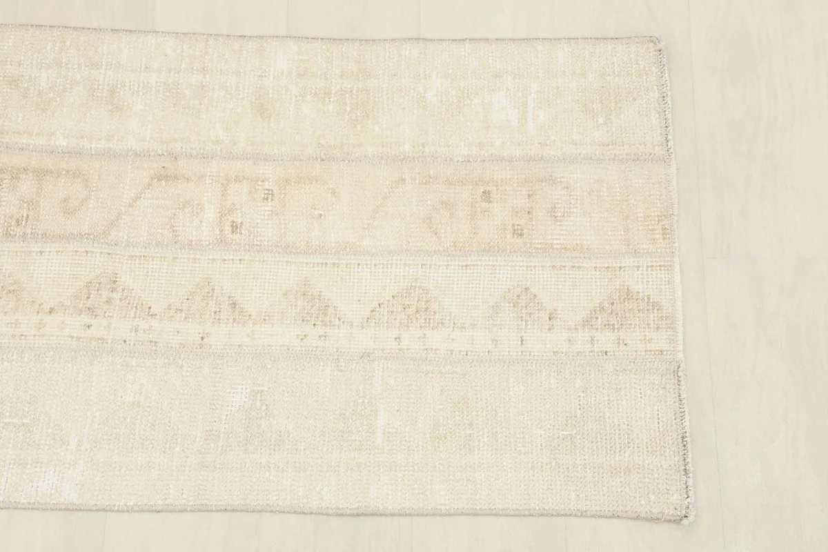 Close-up of the rug's central section, showing the subtle tribal geometric patterns in beige and tan.