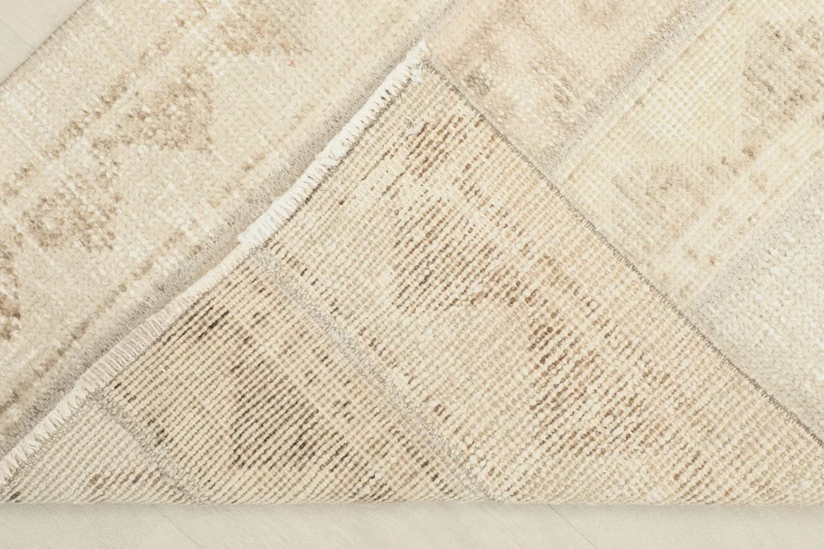 View of the back of the rug, illustrating the cotton foundation and the knotting technique.