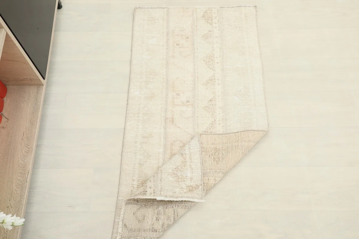 The rug partially folded, showing its flexibility and the reverse side with its tight weave.