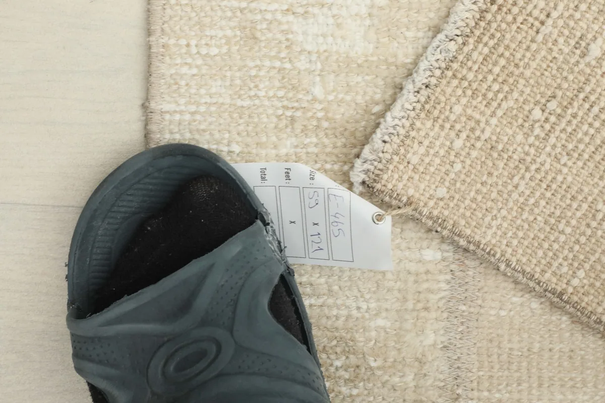 A shoe placed next to the rug, providing a sense of scale for the 1'11" x 4'0" area rug.