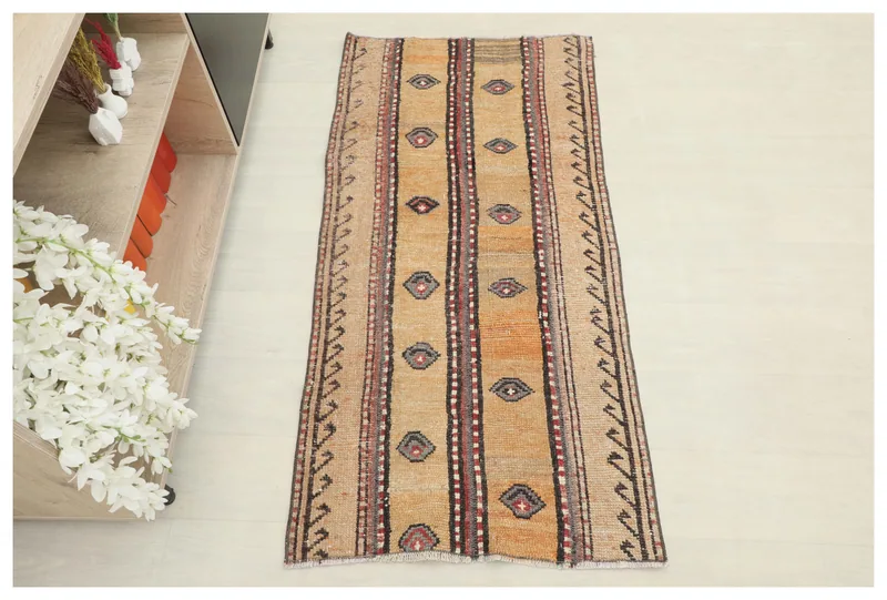 Full top view of the vintage Anatolian rug with tan, orange, red, and gray geometric patterns.