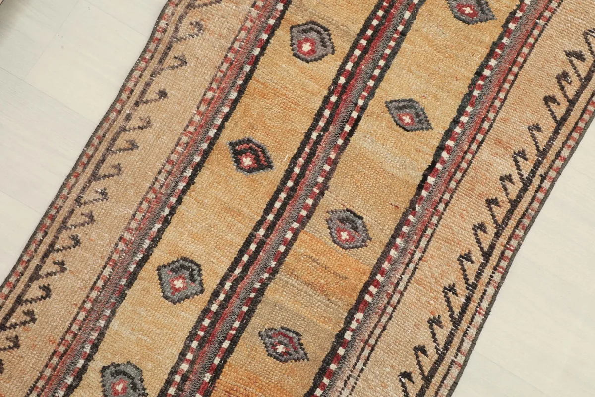 Overhead angled view showing the full length of the rug and its tribal patterns.