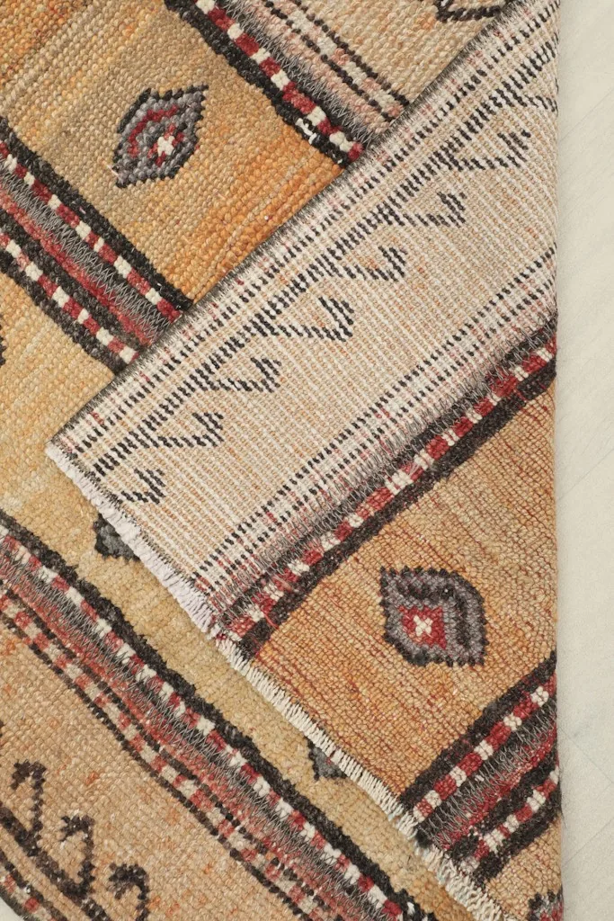 View of the rug's back, showing the cotton foundation and hand-knotting.