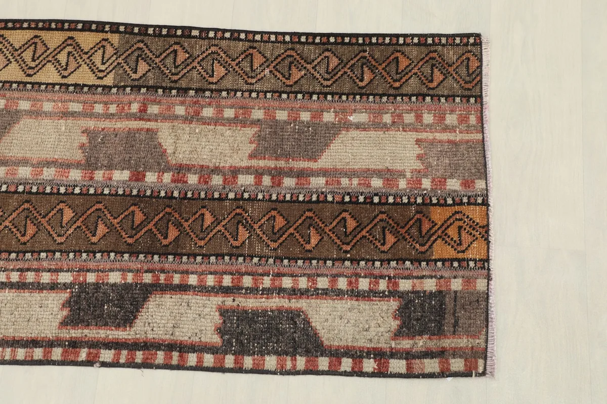 Close-up of one end of the rug, highlighting the varied geometric patterns and color variations.