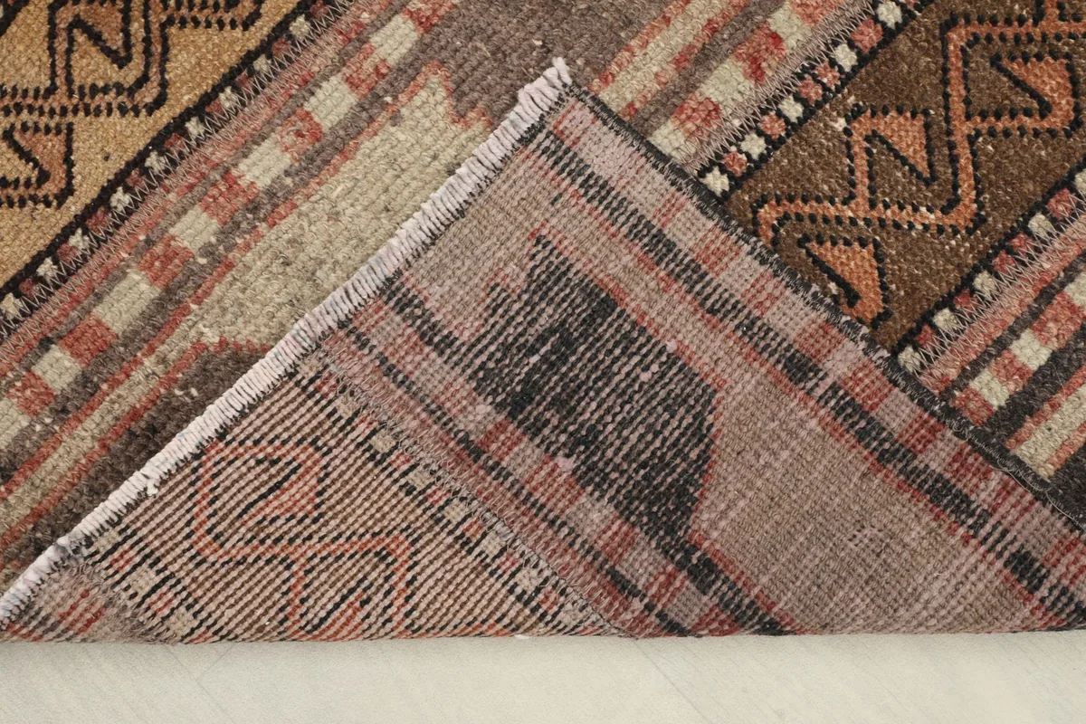 Folded corner revealing the cotton foundation and the reverse side of the hand-knotted rug.