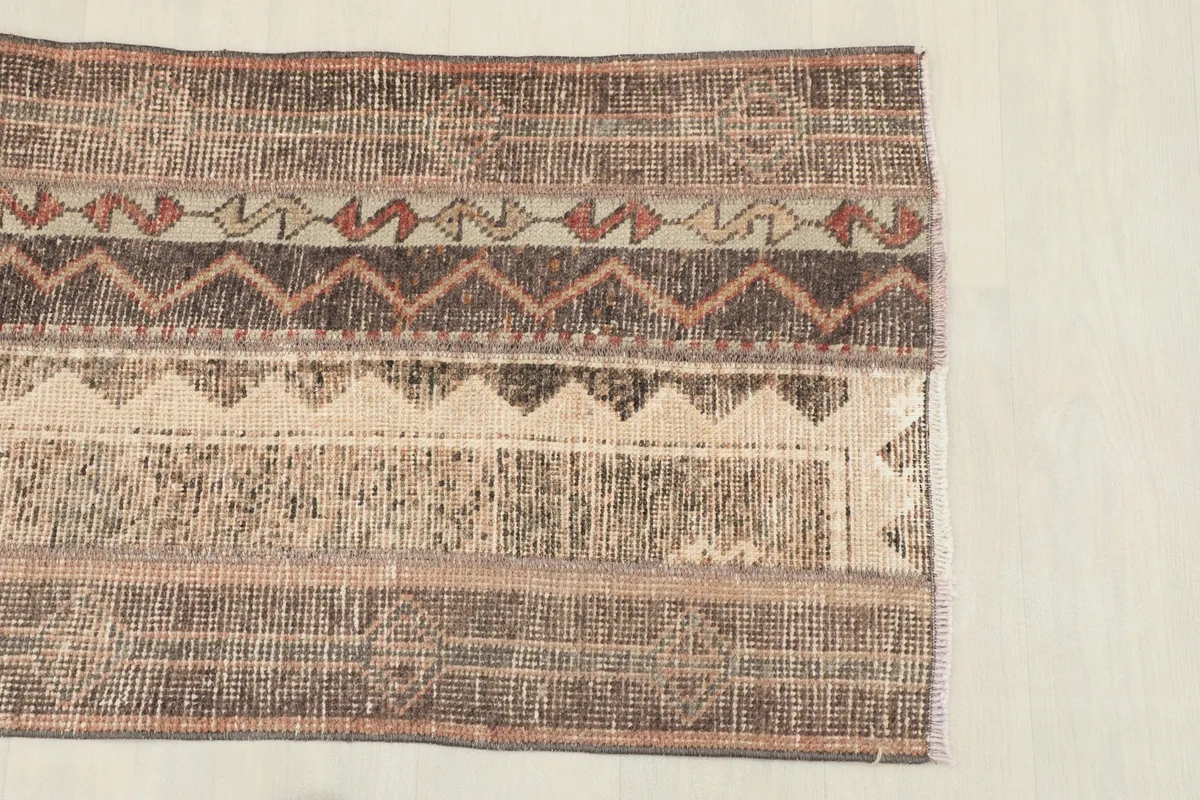 Close-up of the rug's end, highlighting the various striped patterns and colors