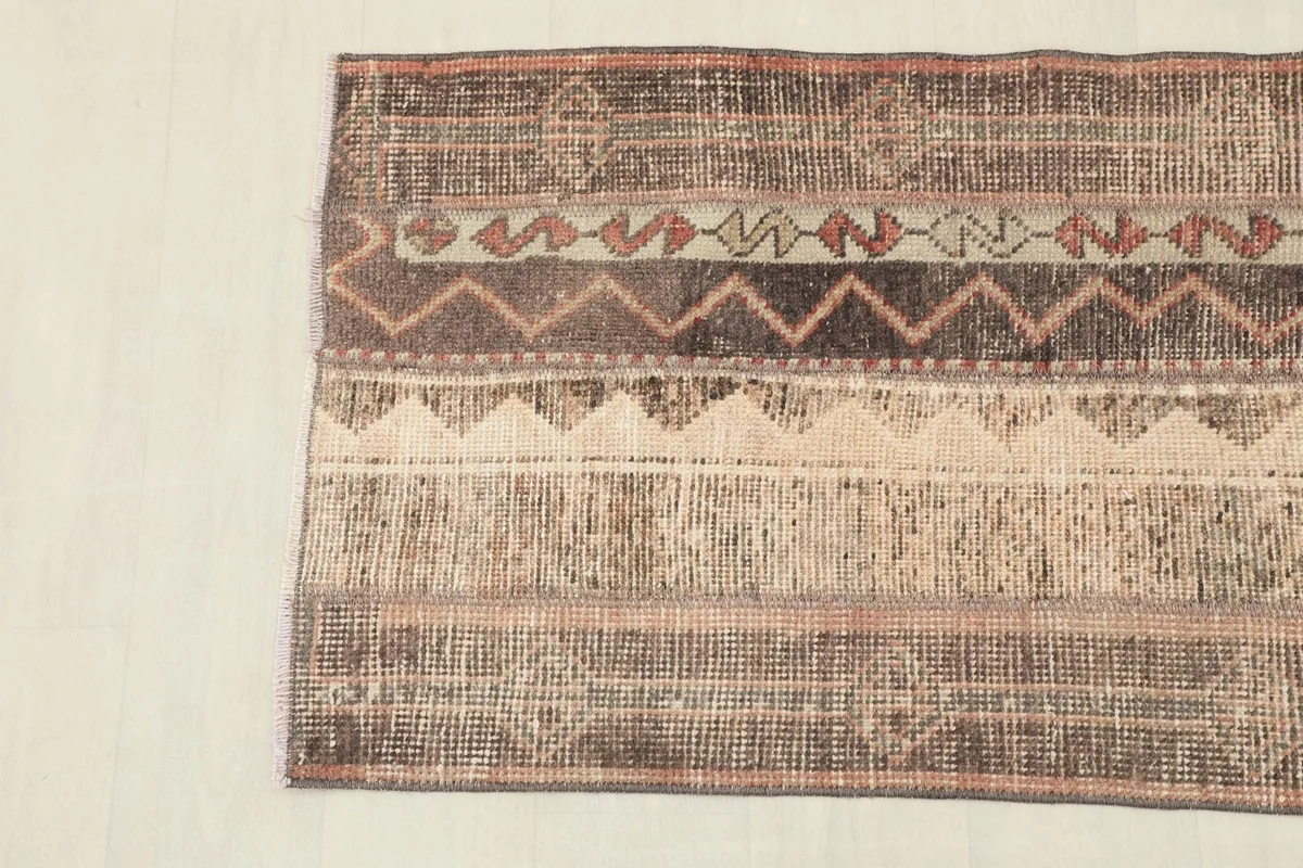 Detailed view of the rug's geometric motifs and color variations