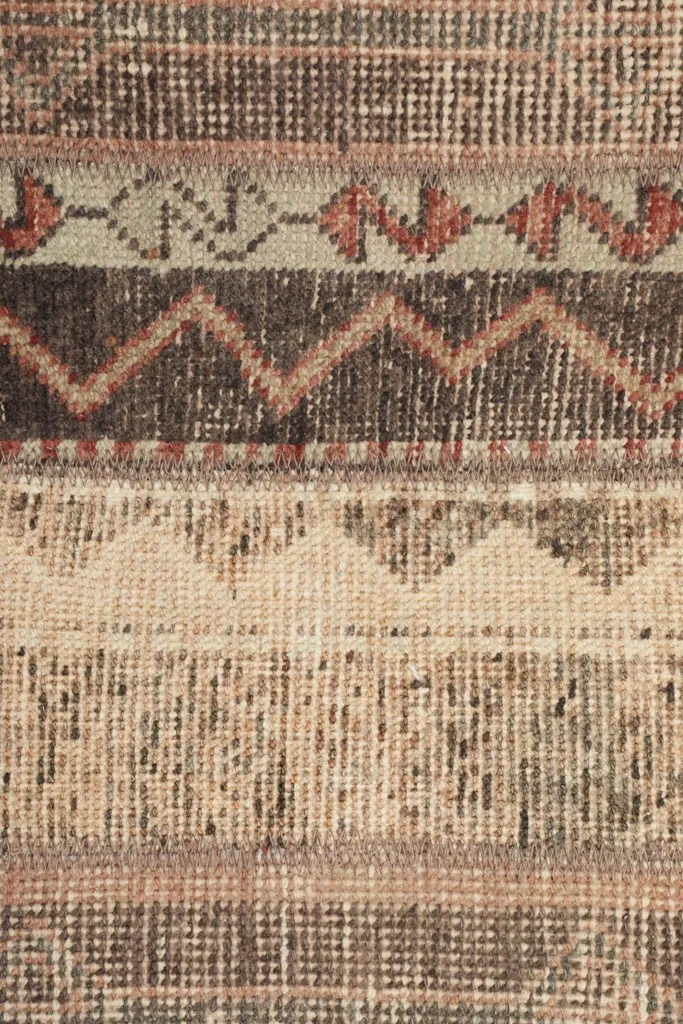 Close-up of the rug's low wool pile, showing the intricate hand-knotted weave