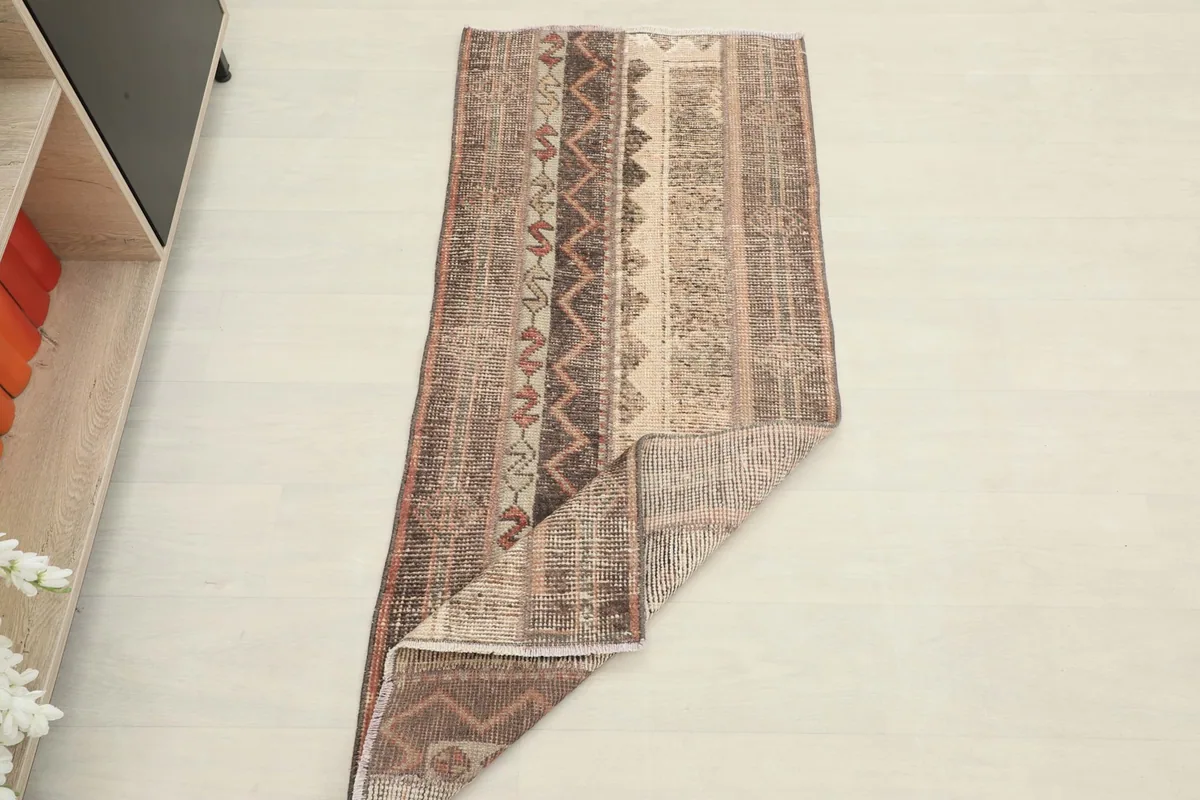 Overhead view of the rug with a corner folded back, displaying the full design