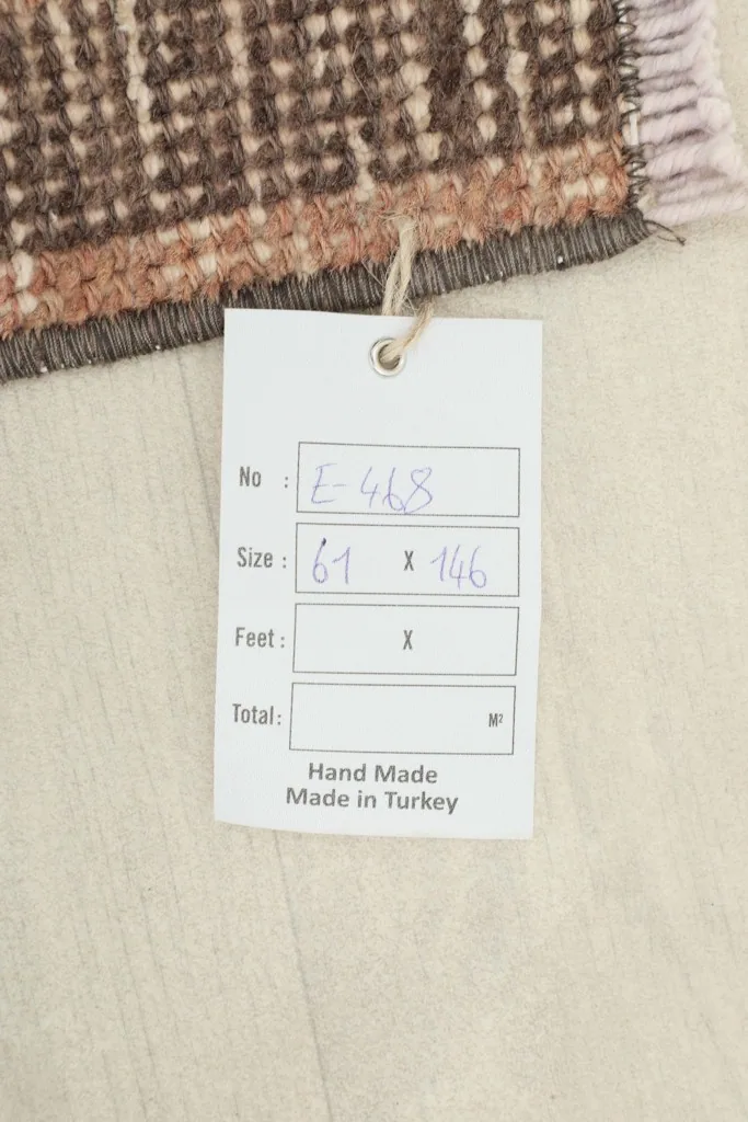 Tag on the rug confirming its handmade origin and dimensions in centimeters