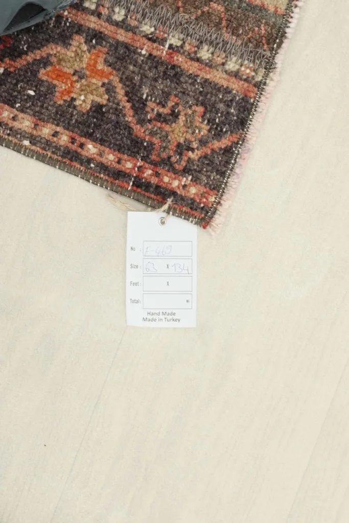Corner of the rug with a tag, showing information about its origin and material.