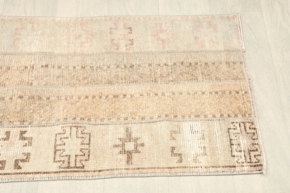 Close view of the left side of the rug, showcasing different patchwork sections and faint patterns