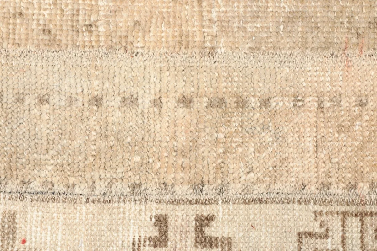 Extreme close-up of the low wool pile and subtle color variations in the rug