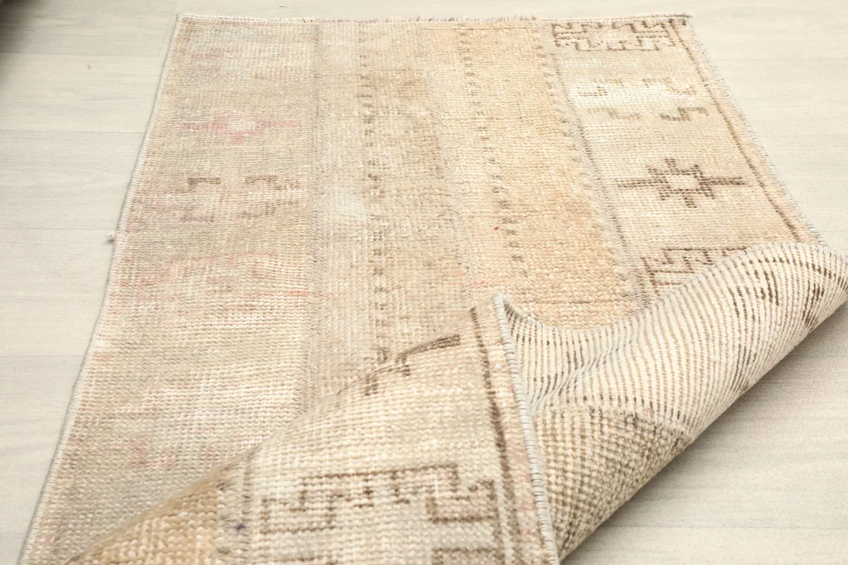 Rug partially folded, showing the flexibility and thickness of the vintage hand-knotted construction