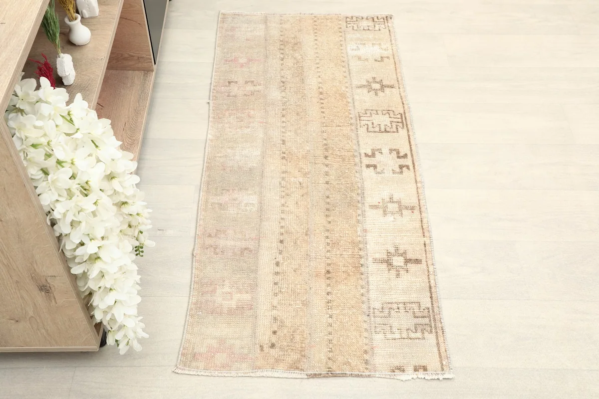 Overhead view of the beige patchwork rug, showing its rectangular shape and colors