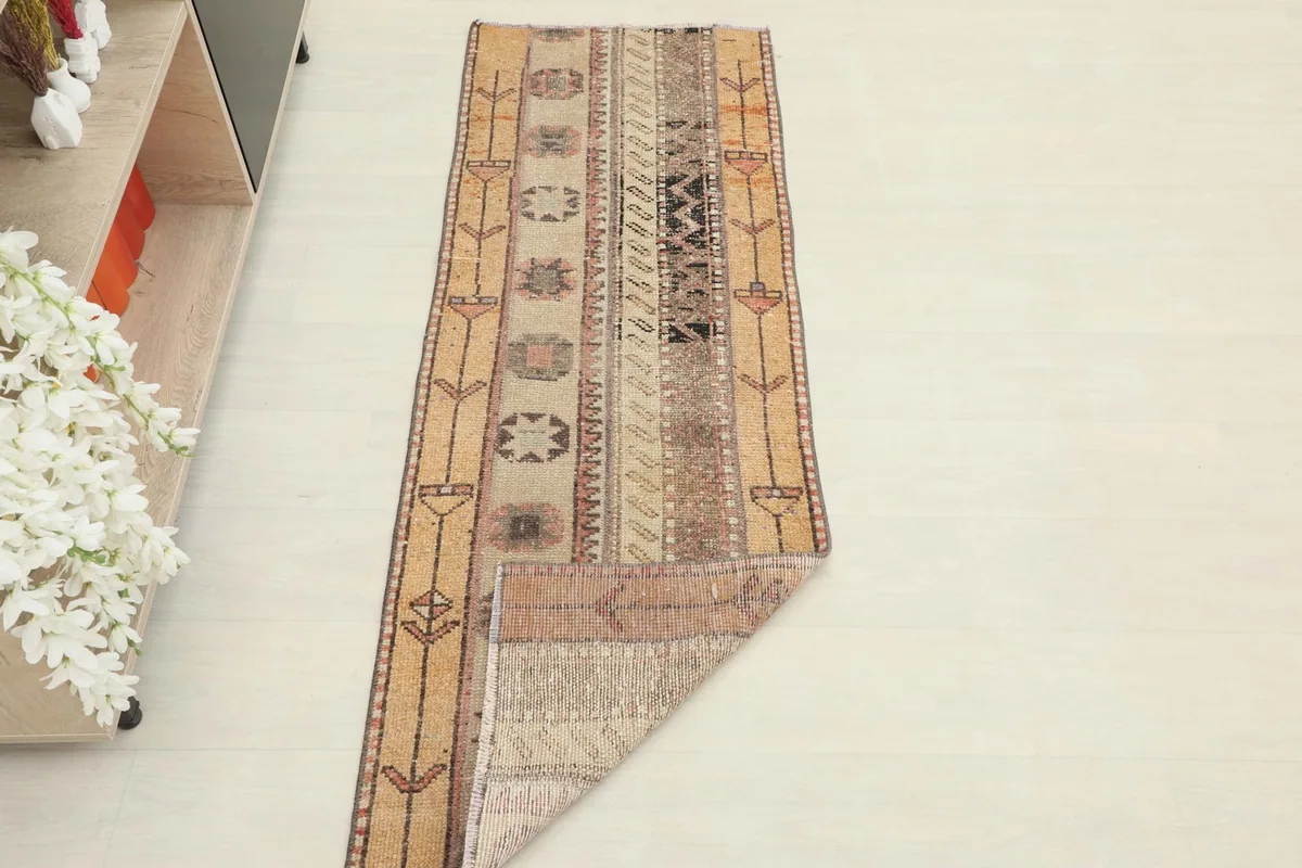 The runner rug partially unrolled, showing its full length and design in a room setting