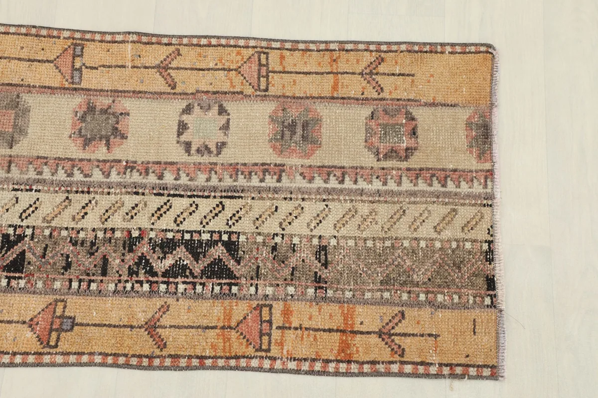 Close-up view of the geometric patterns and color variations on one end of the runner rug