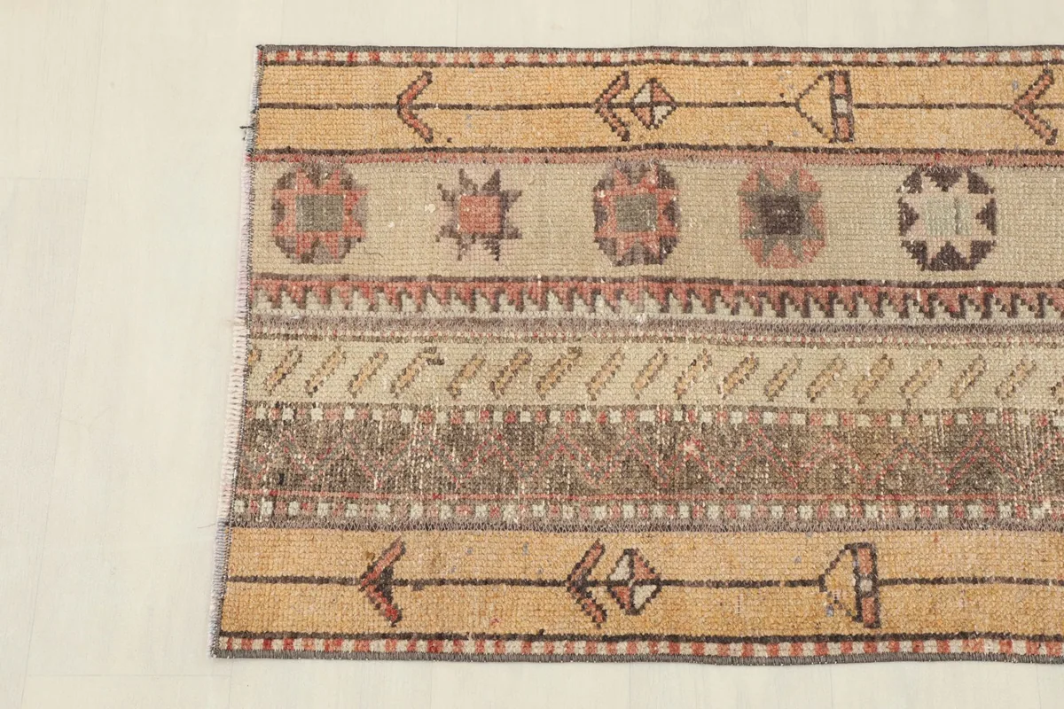 Detailed view showing the distinct striped bands and tribal motifs in tan, rust, and black