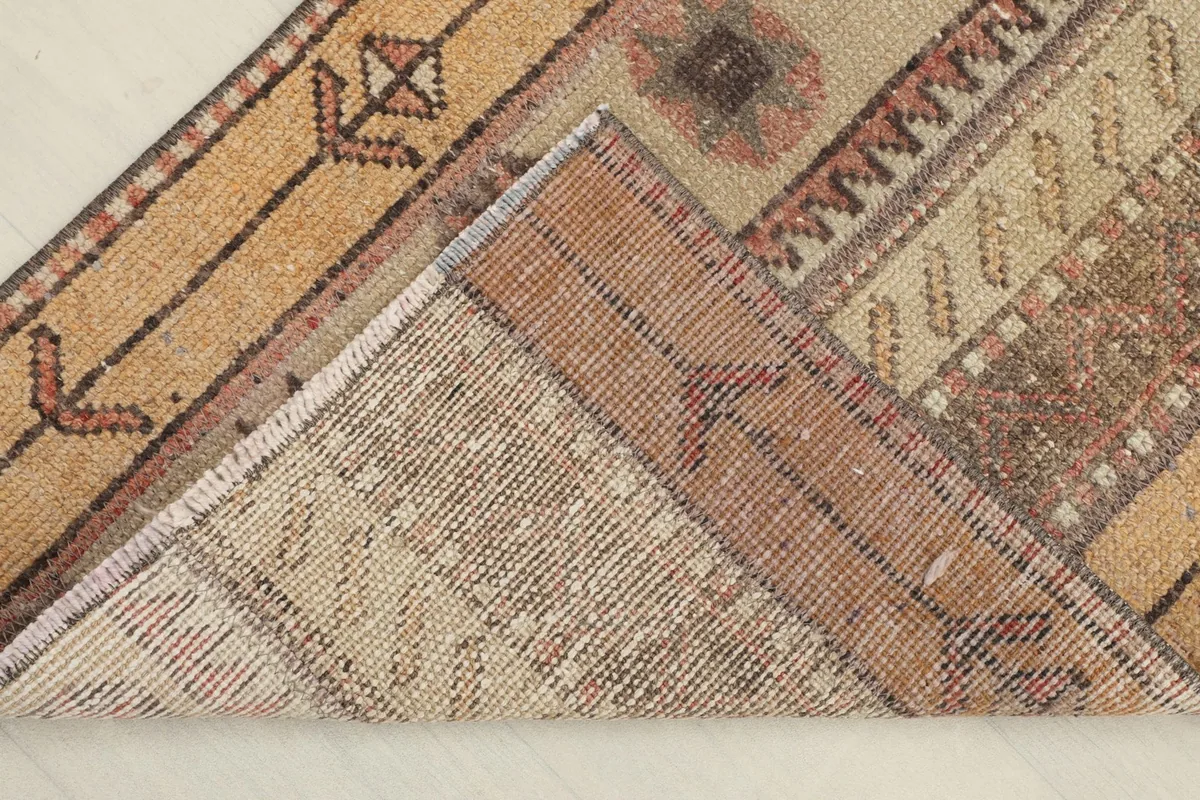 Corner folded to reveal the hand-knotted construction and cotton foundation on the back of the rug