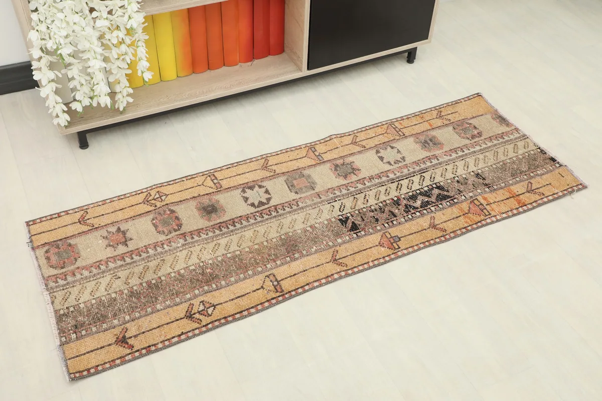 Overhead view of the tan and rust striped runner rug with tribal and geometric patterns