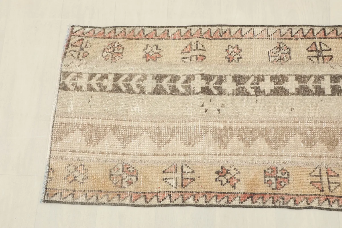 Detail view of the rug's end, showcasing the patterned border and the color variations.