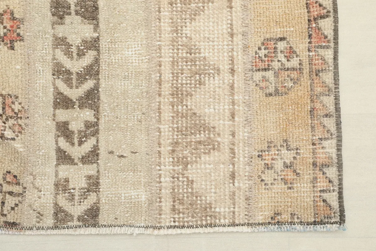 Close-up of the rug's edge and fringe, detailing the craftsmanship and minor wear.