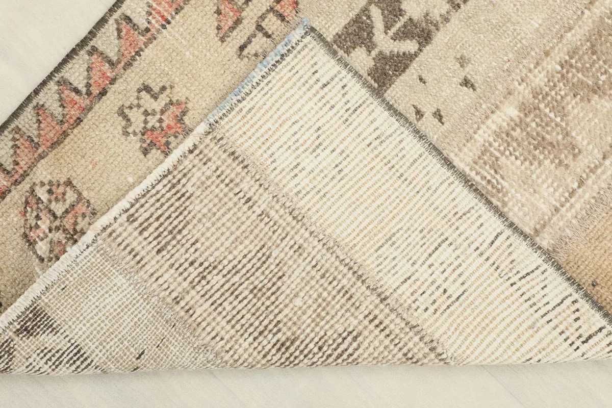 View of the back of the rug, showing the cotton foundation and the knotting structure.