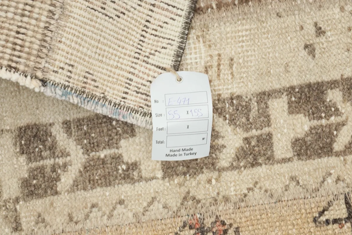 Close-up of the rug's tag, indicating its origin from Turkey and hand-knotted nature.