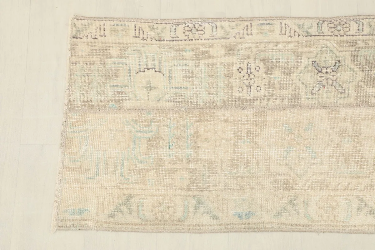 Detailed view of the rug's surface, revealing the soft texture and distressed appearance of the vintage wool.
