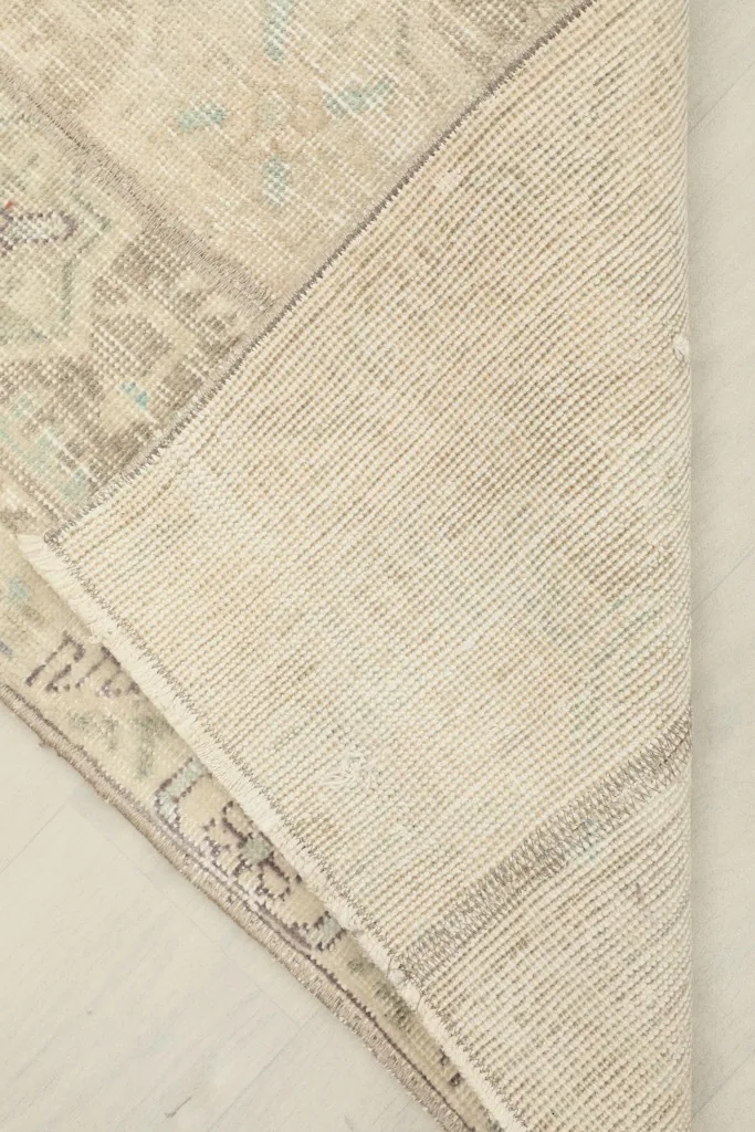 Underside view of the rug, showing the cotton foundation and the reverse of the hand-knotted construction.