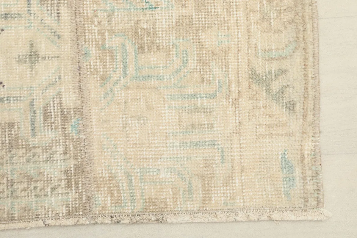 Detail of the rug's edge, including the short, natural cotton fringe and finished side binding.