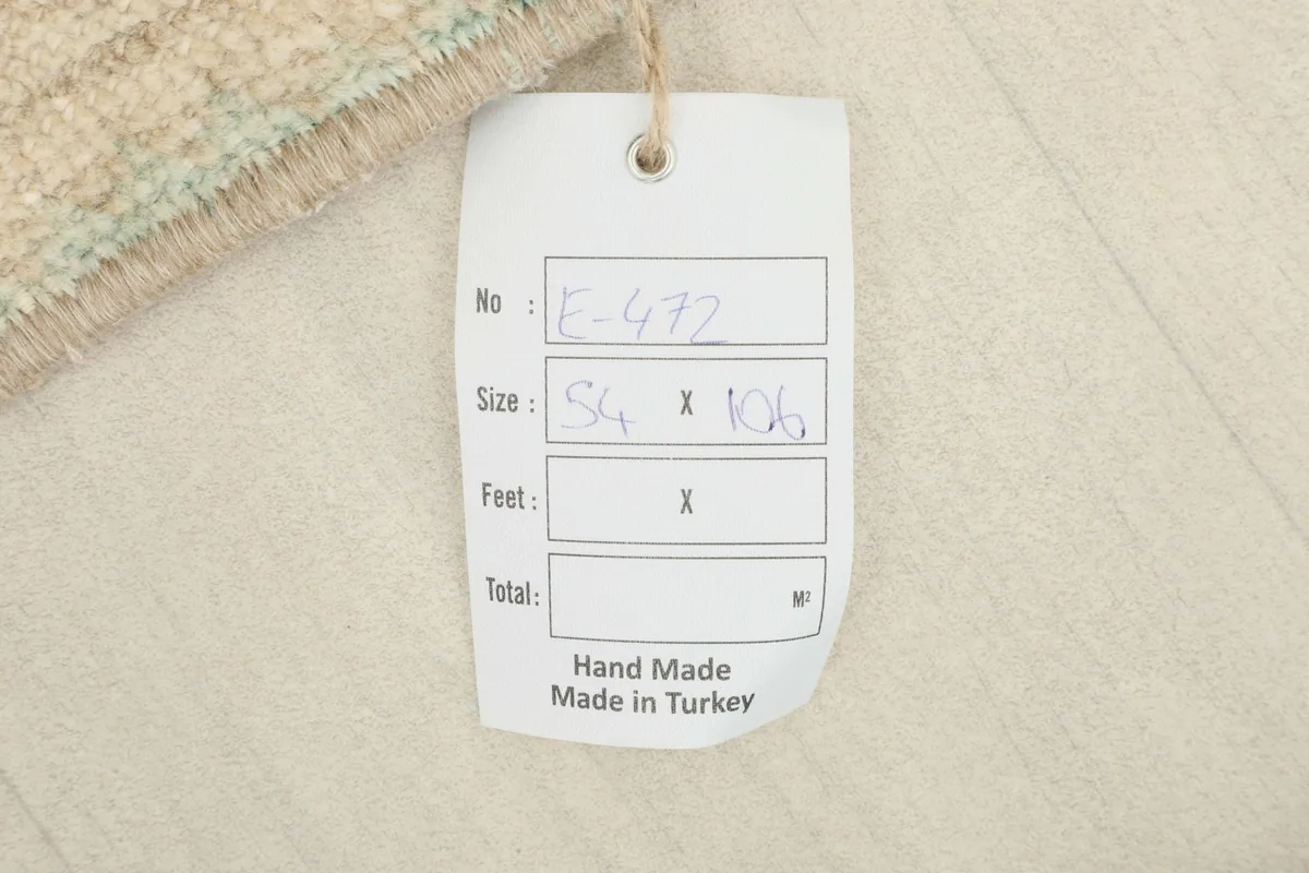Close-up of the product tag, confirming the rug's dimensions and its hand-made origin in Turkey.