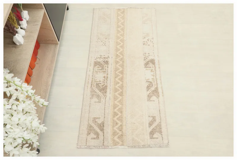 Full overhead view of the beige and tan vintage Anatolian area rug on a light floor.