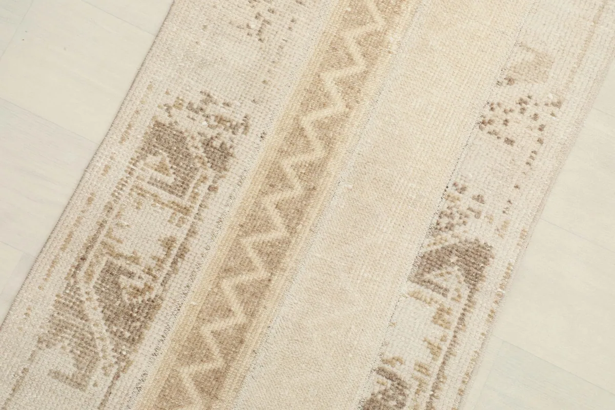Close-up angled shot of the rug's distressed texture and geometric designs.