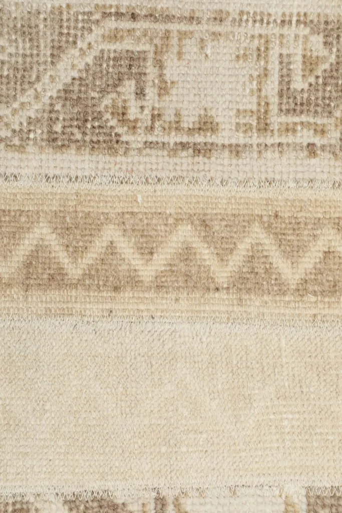 Extreme close-up showing the low wool pile and the intricate hand-knotted texture.