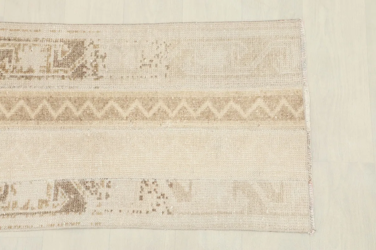 Close overhead view of the rug's top section, highlighting the tan and beige weaving.
