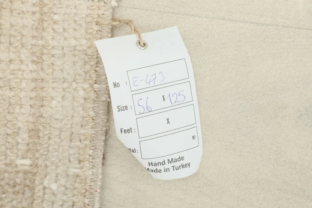 Close-up of the product tag attached to the rug, showing size and origin details.