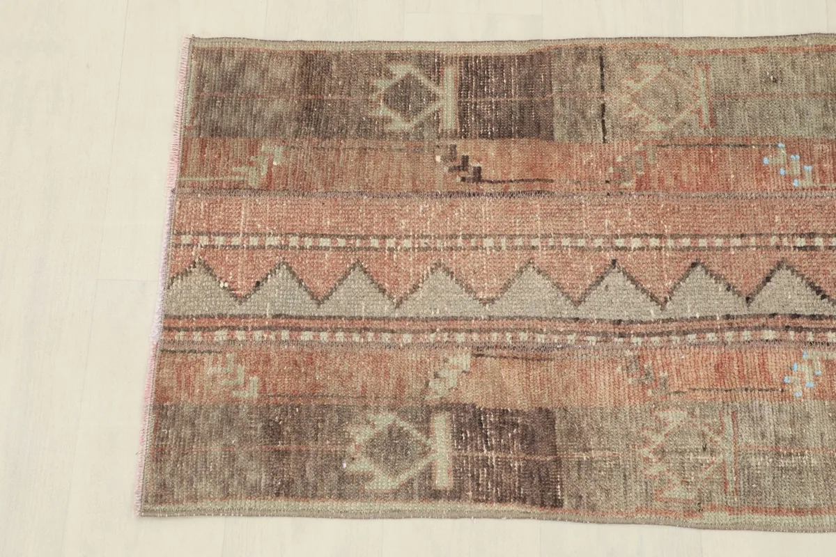Detailed view of the rug's patterns, showcasing rose, gray, and brown color variations