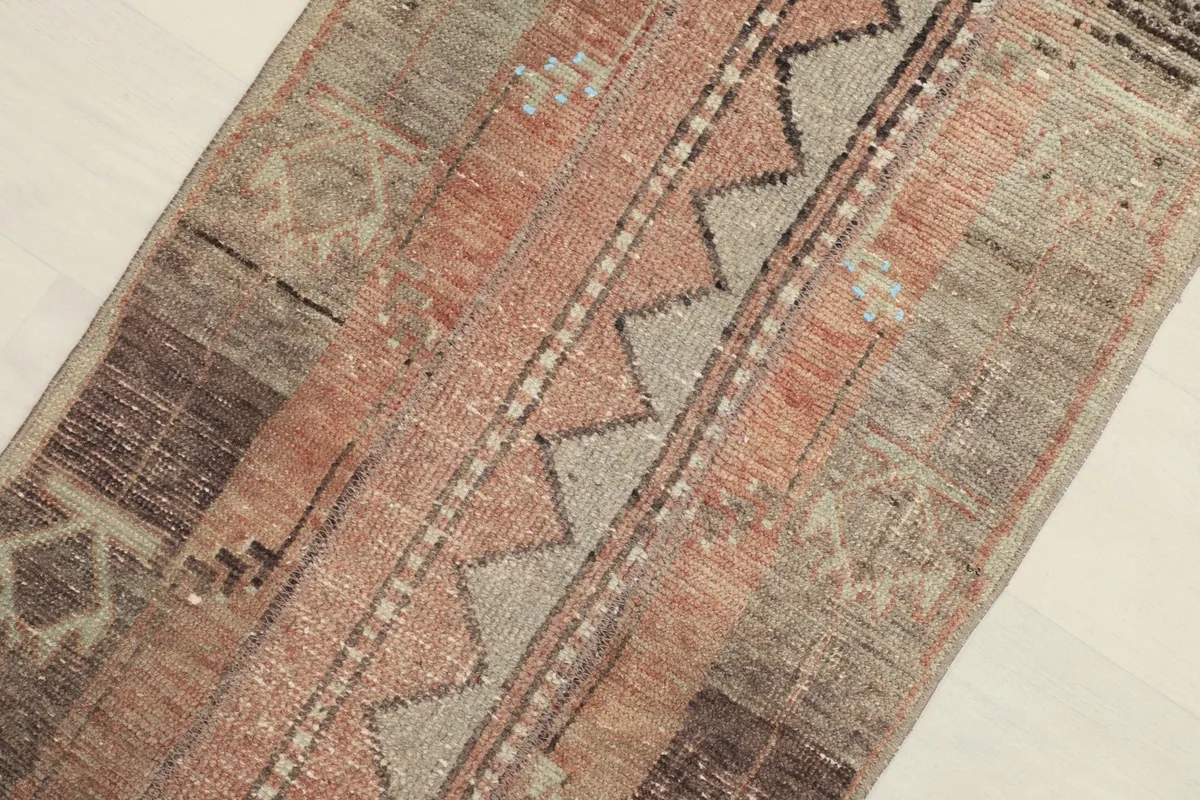 Angled close-up on the central geometric design and texture of the vintage wool pile