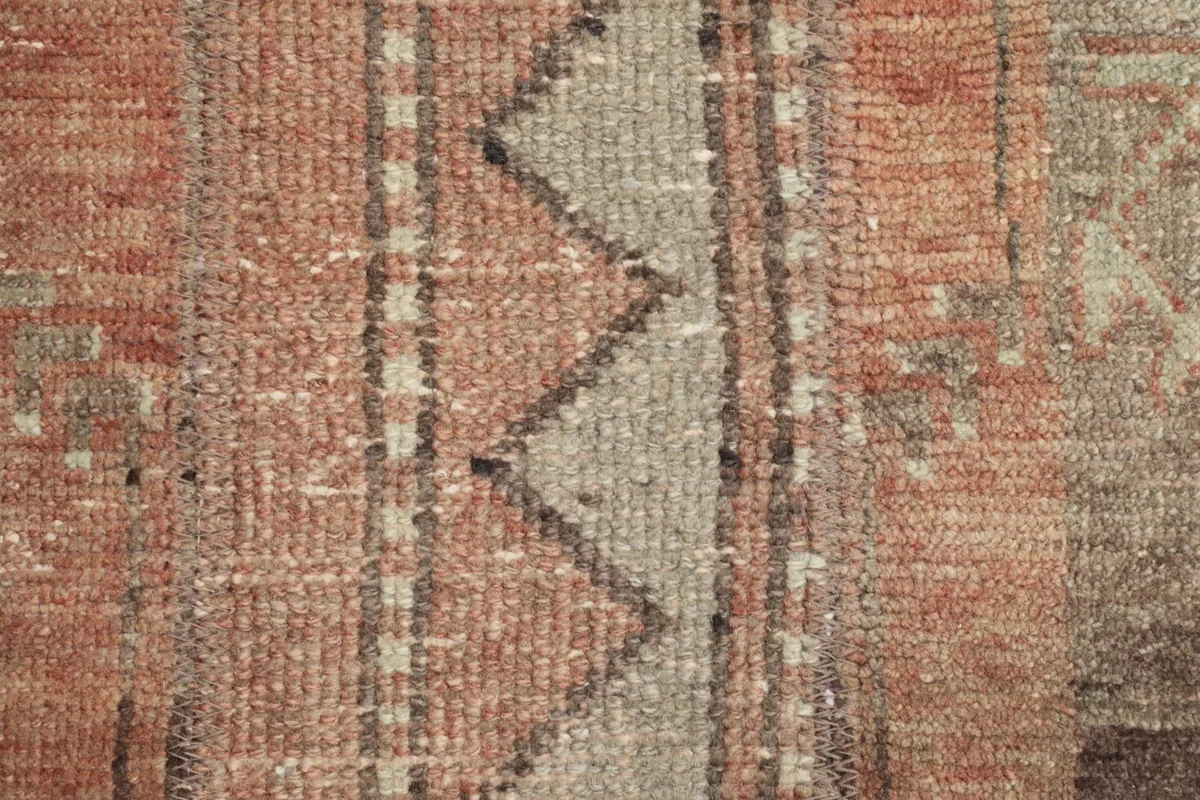 Extreme close-up of the low wool pile, highlighting the hand-knotted texture and colors