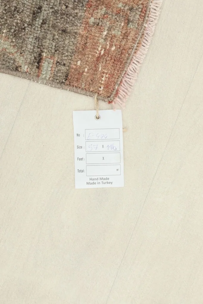 Small white tag on the rug, indicating its hand-knotted origin and size