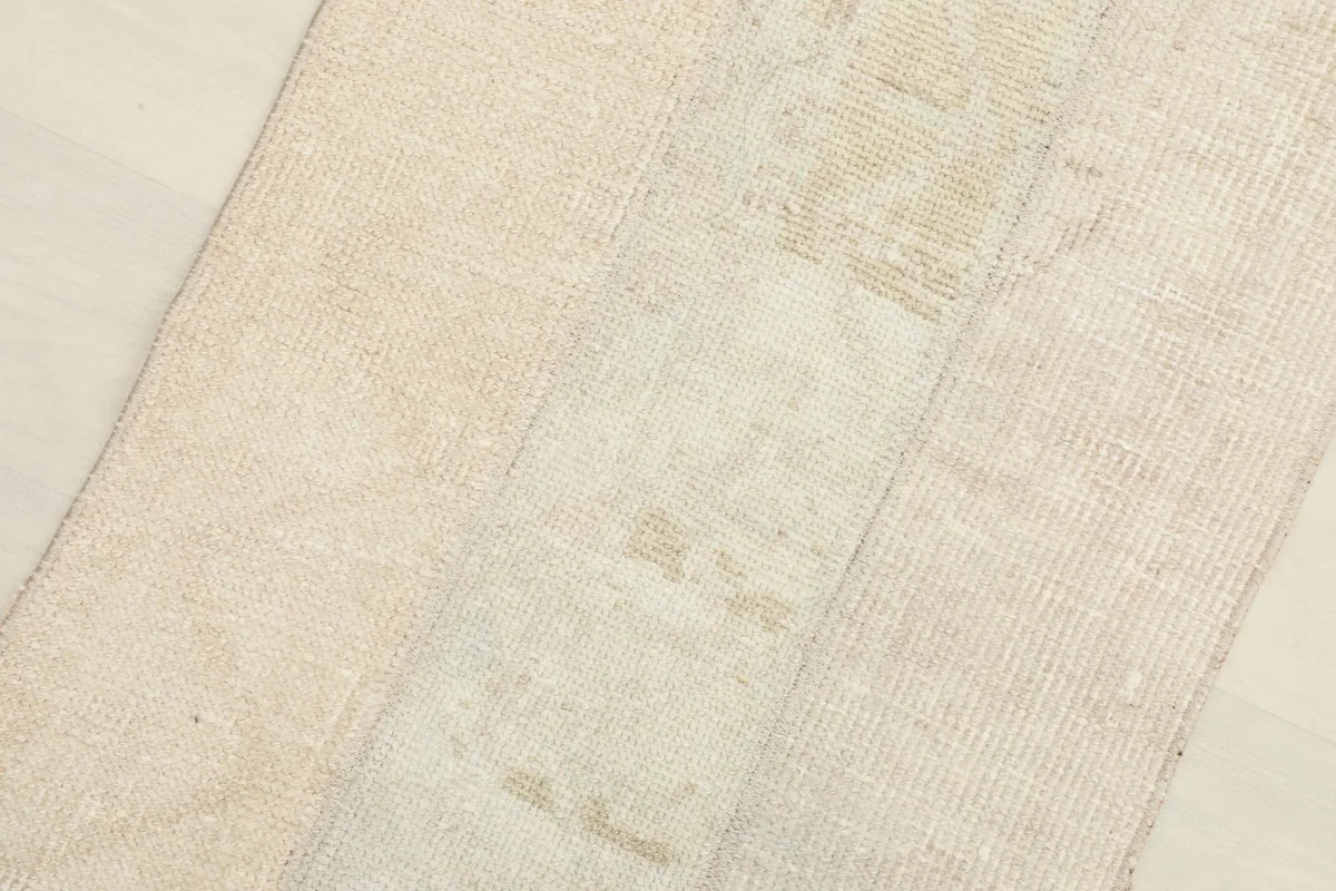 Angled close-up of the rug's surface, revealing the low pile and textured appearance of the wool.