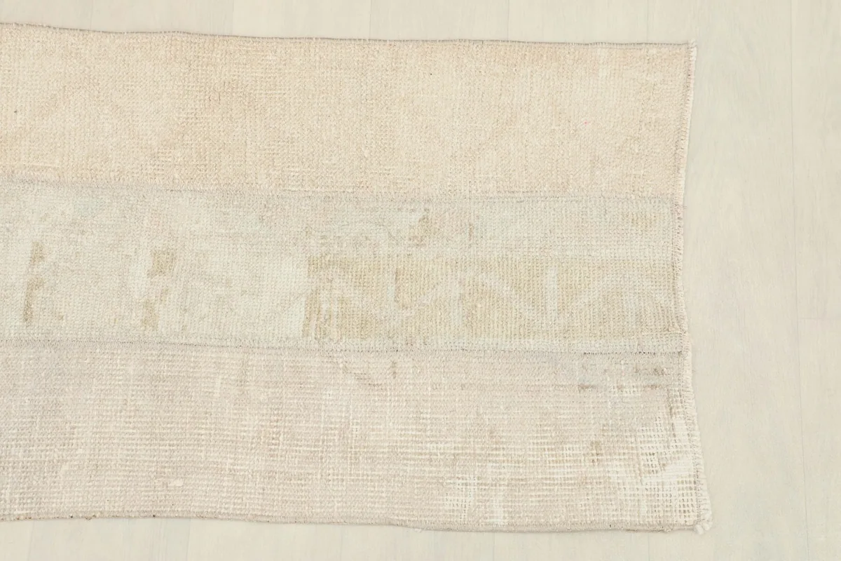 Close-up view of the rug's patchwork sections, highlighting the subtle tonal variations and texture.