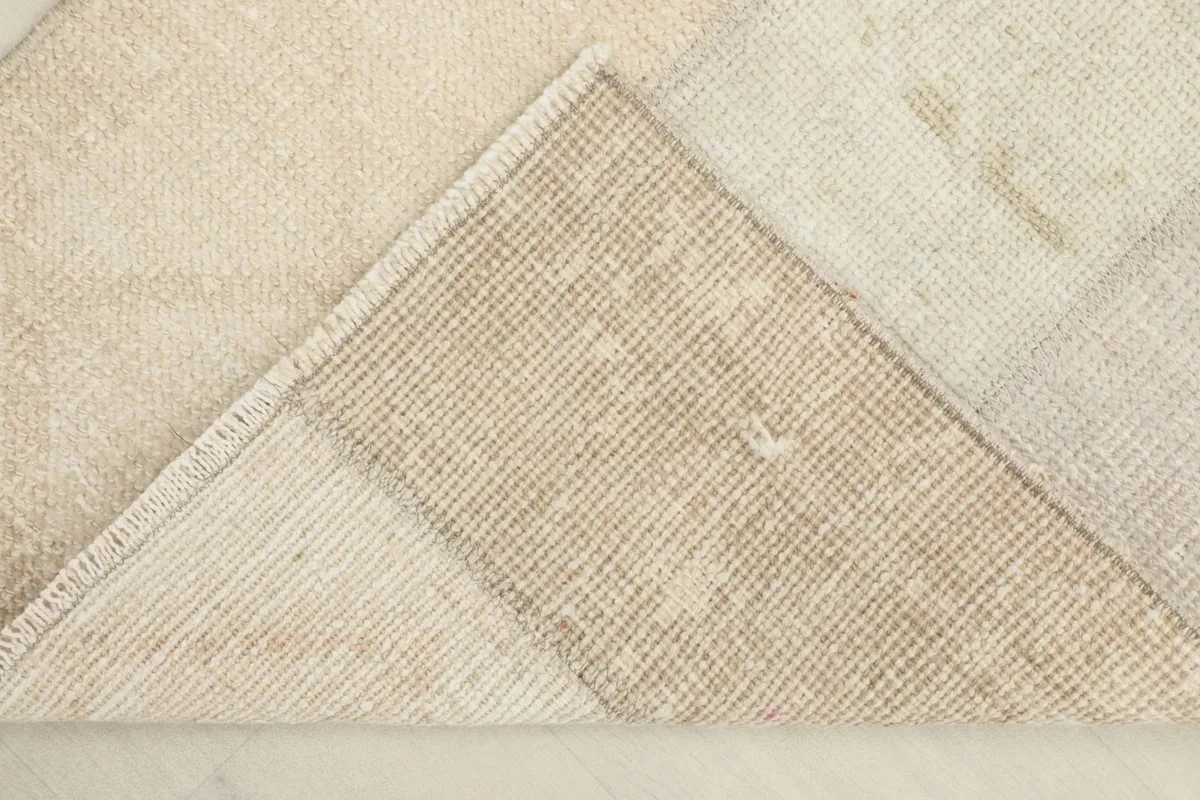 View of the back of the rug, revealing the cotton foundation and the hand-knotted construction.