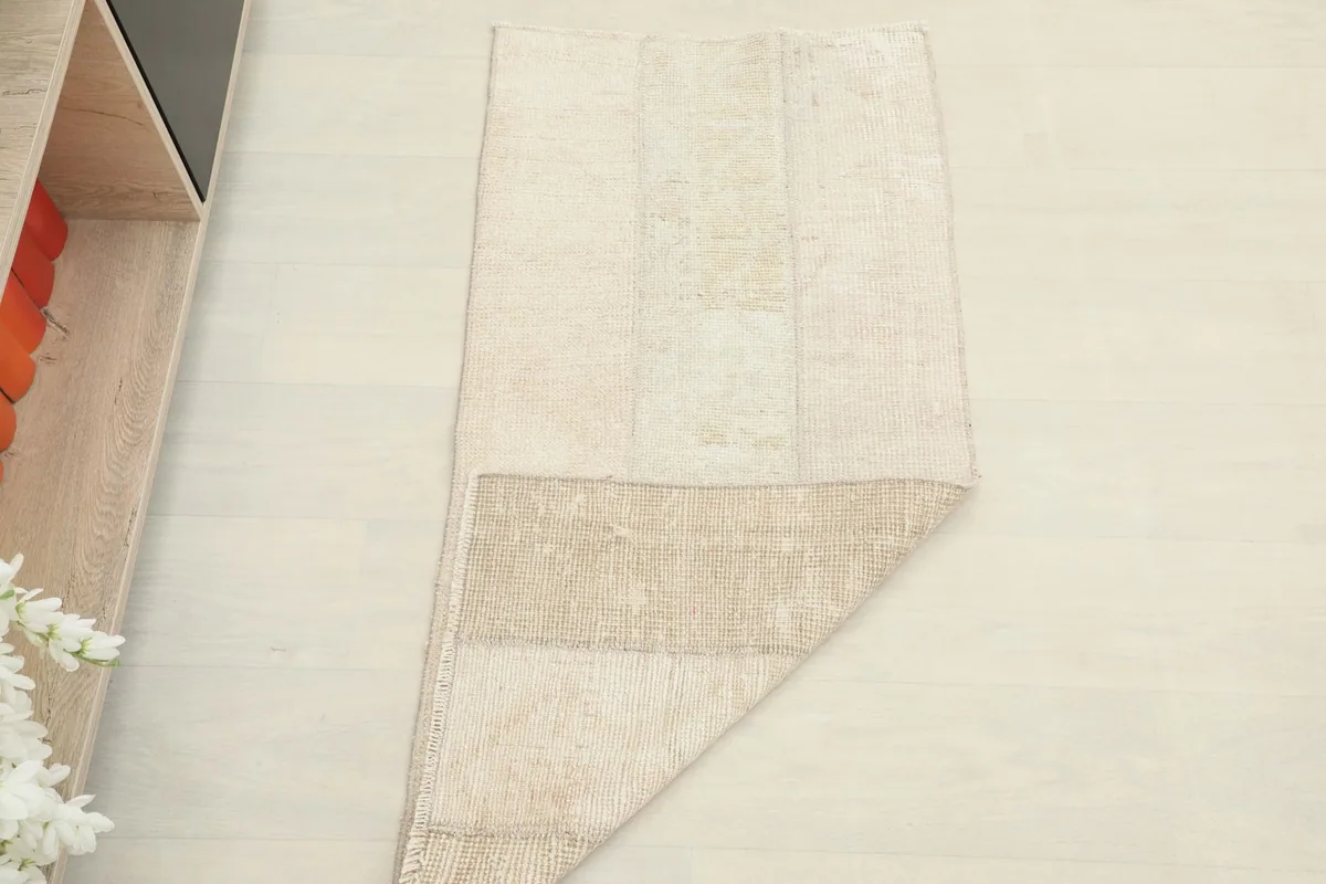 The rug folded back to show both the pile side and the cotton foundation, indicating its structure.