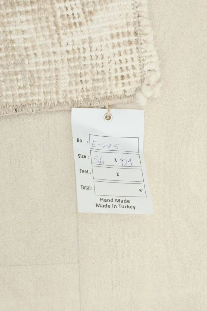 A tag attached to the rug, displaying size information and confirming it is hand-made in Turkey.