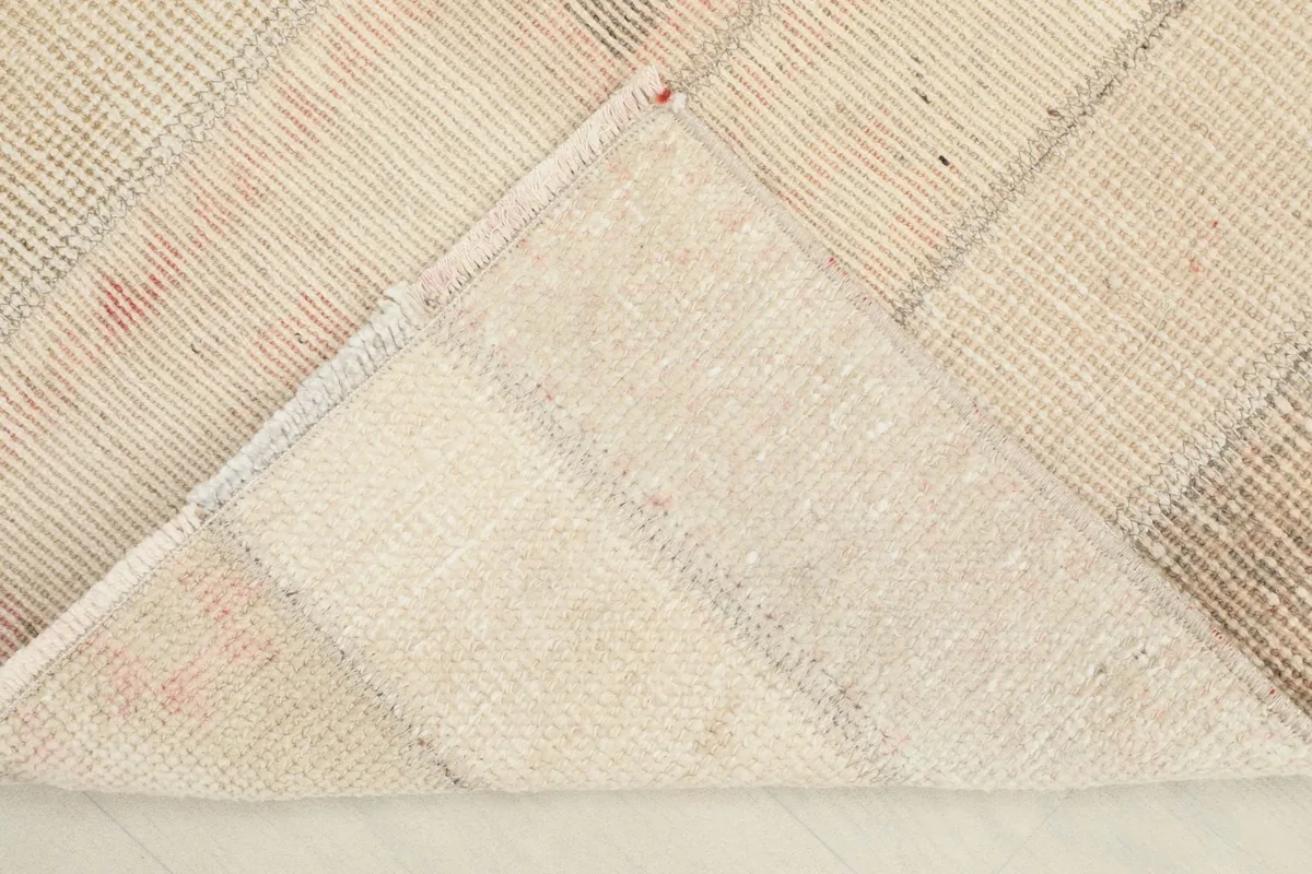 View of the rug's underside, showing the cotton foundation and hand-knotted construction.