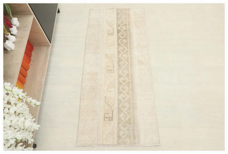 Full top view of the beige and tan tribal pattern vintage Anatolian area rug on a white background.