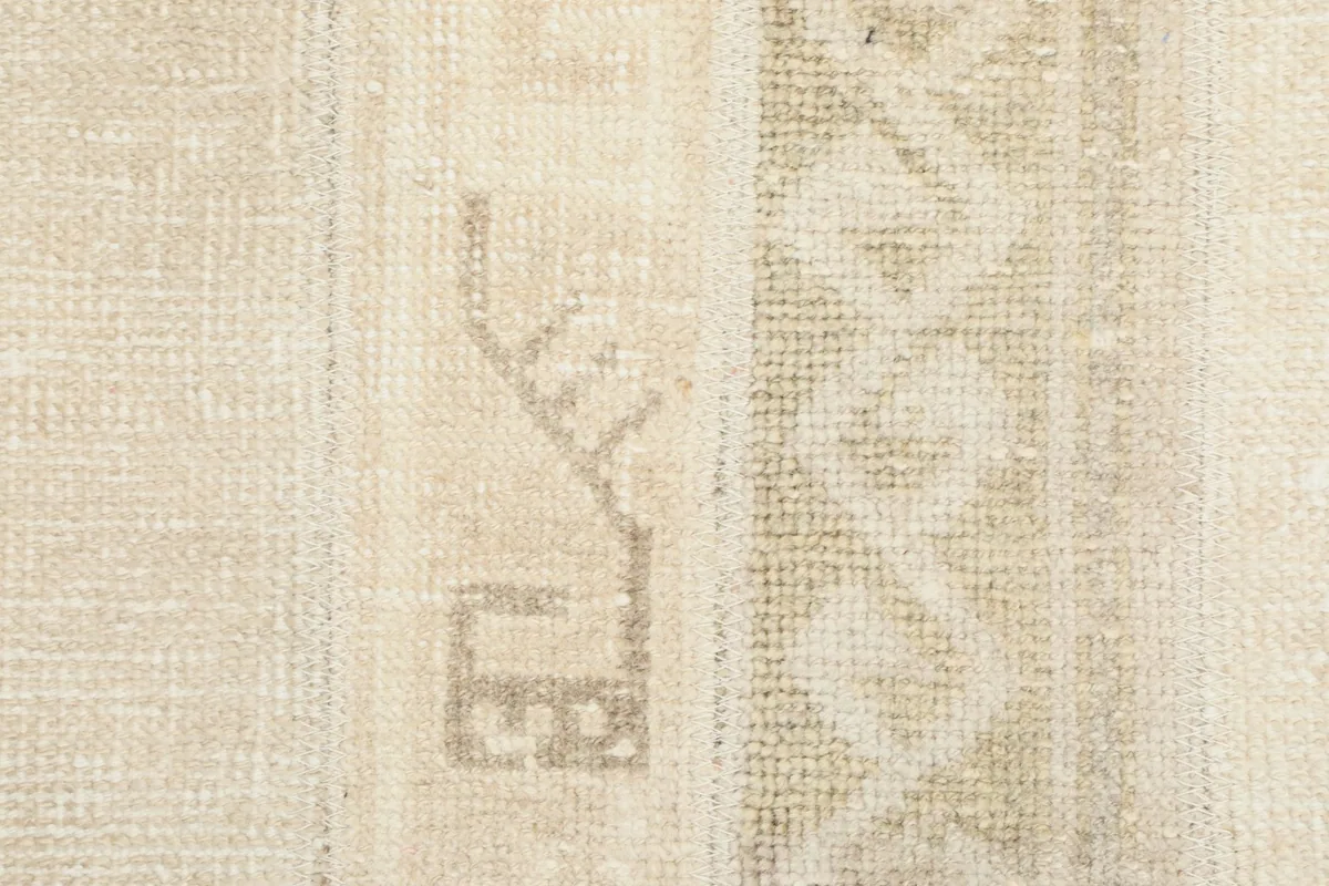 Extreme close-up on a specific tribal motif, revealing the hand-knotted texture and wool fibers.